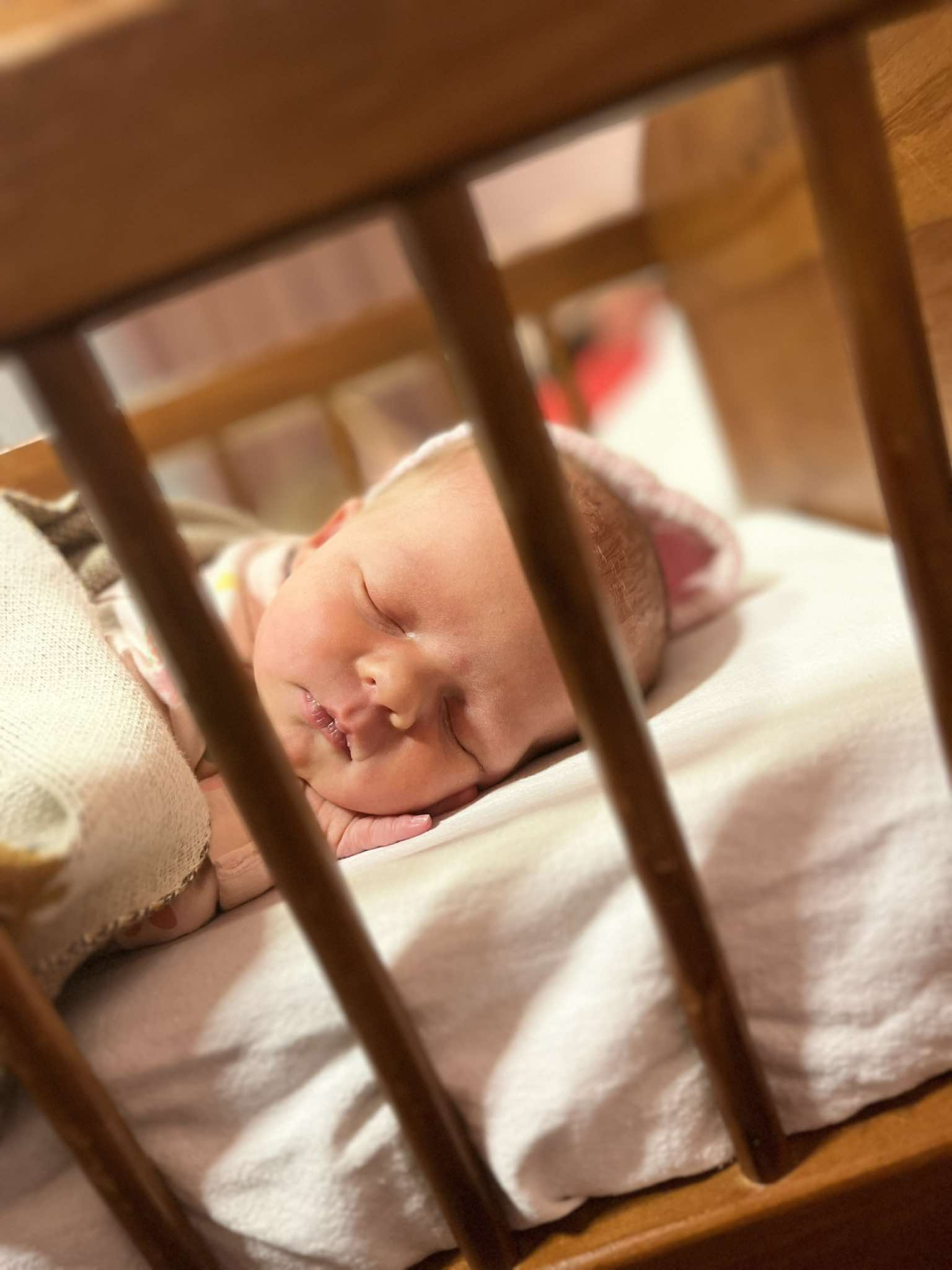 A photo of a sleeping infant in a cot.