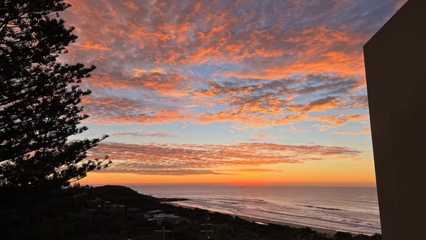 A photograph of the sun about to rise over the ocean.